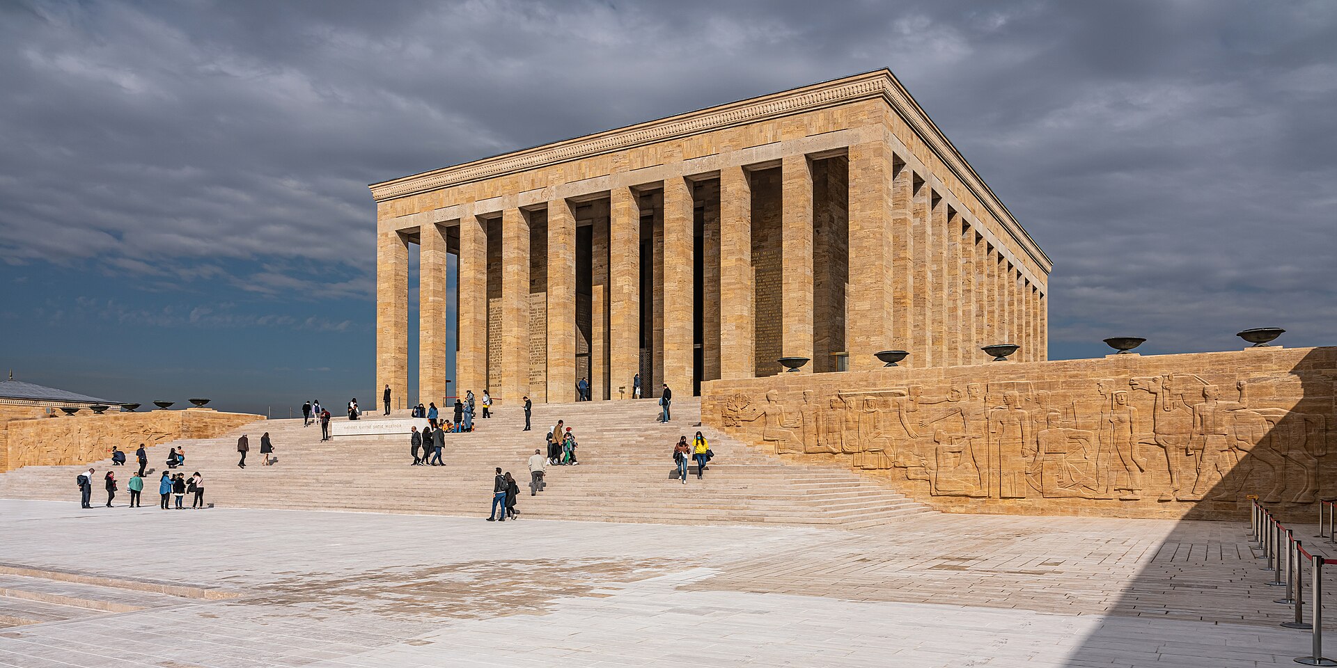 A wide view of Anıtkabir's mausoleum and ceremonial plaza beneath a cloud-streaked sky in Ankara