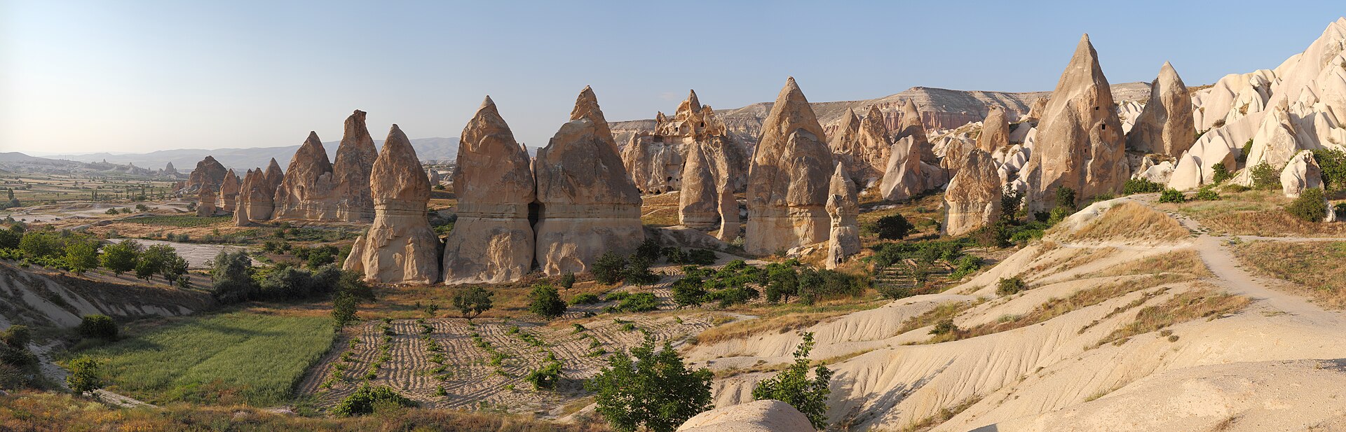 Panoramic view of Cappadocia's fairy chimneys, carved rock formations and cultivated valley floor