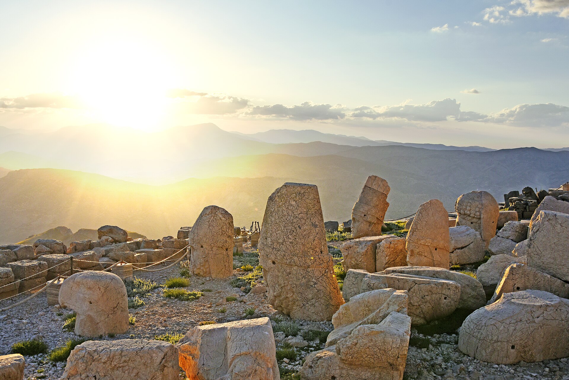 Colossal stone heads on Mount Nemrut's western terrace beneath warm sunset light