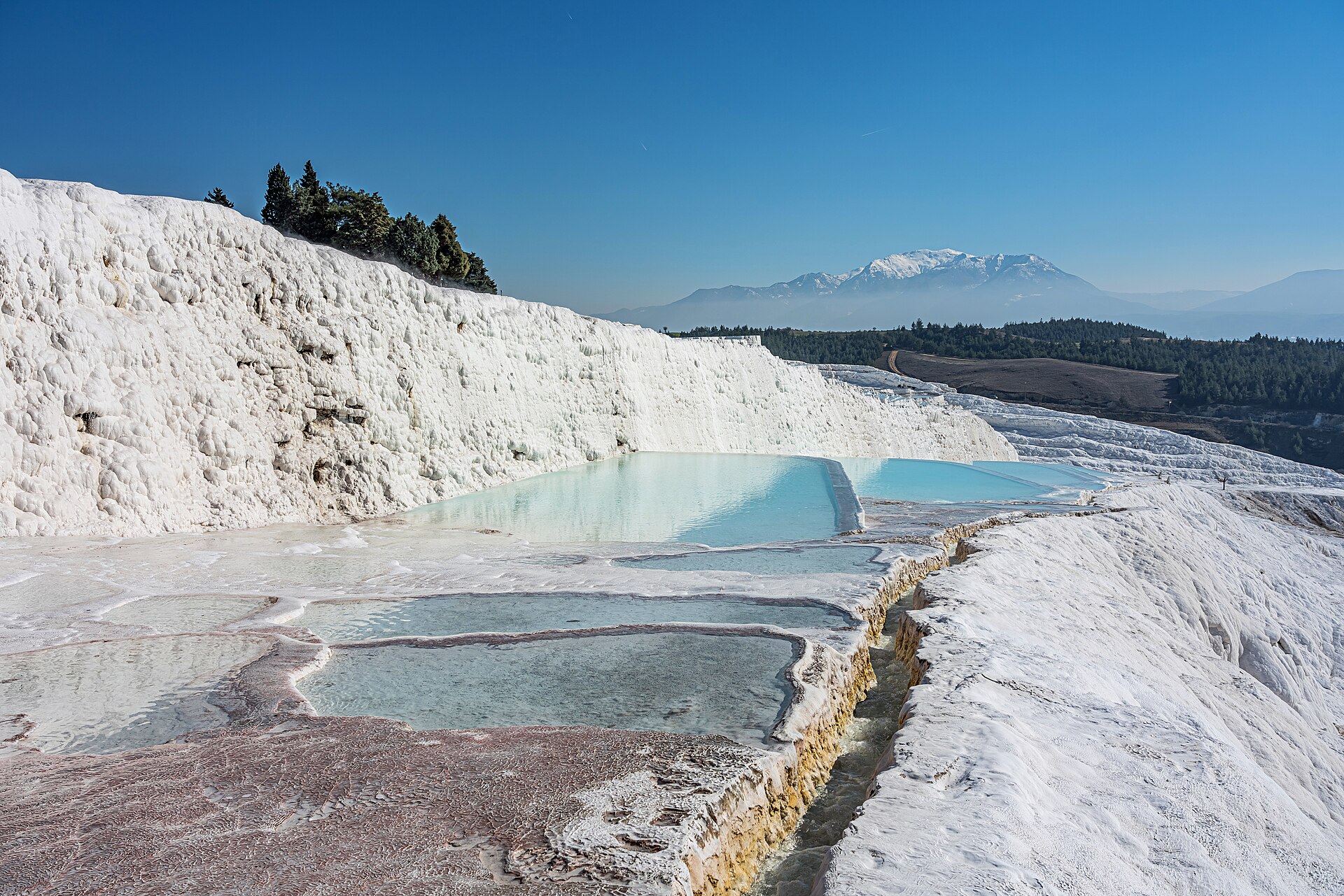 White travertine terraces and thermal pools in Pamukkale, Türkiye